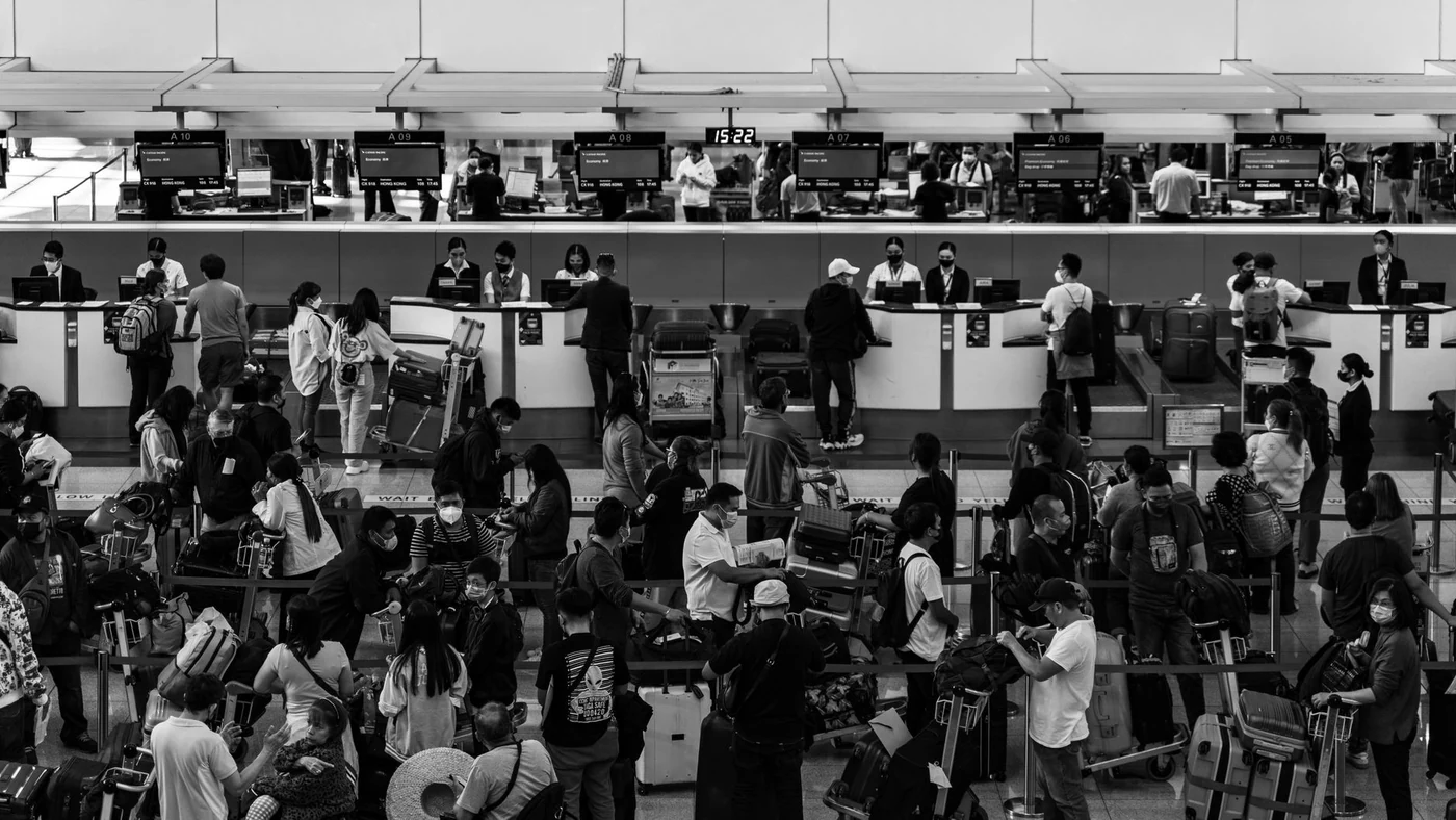 Passageiros e funcionários em balcões de atendimento de um aeroporto