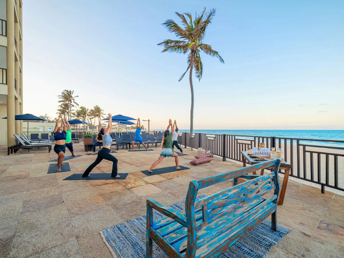 Aula de ioga em um deque de frente para o mar no Acqua Beach Park