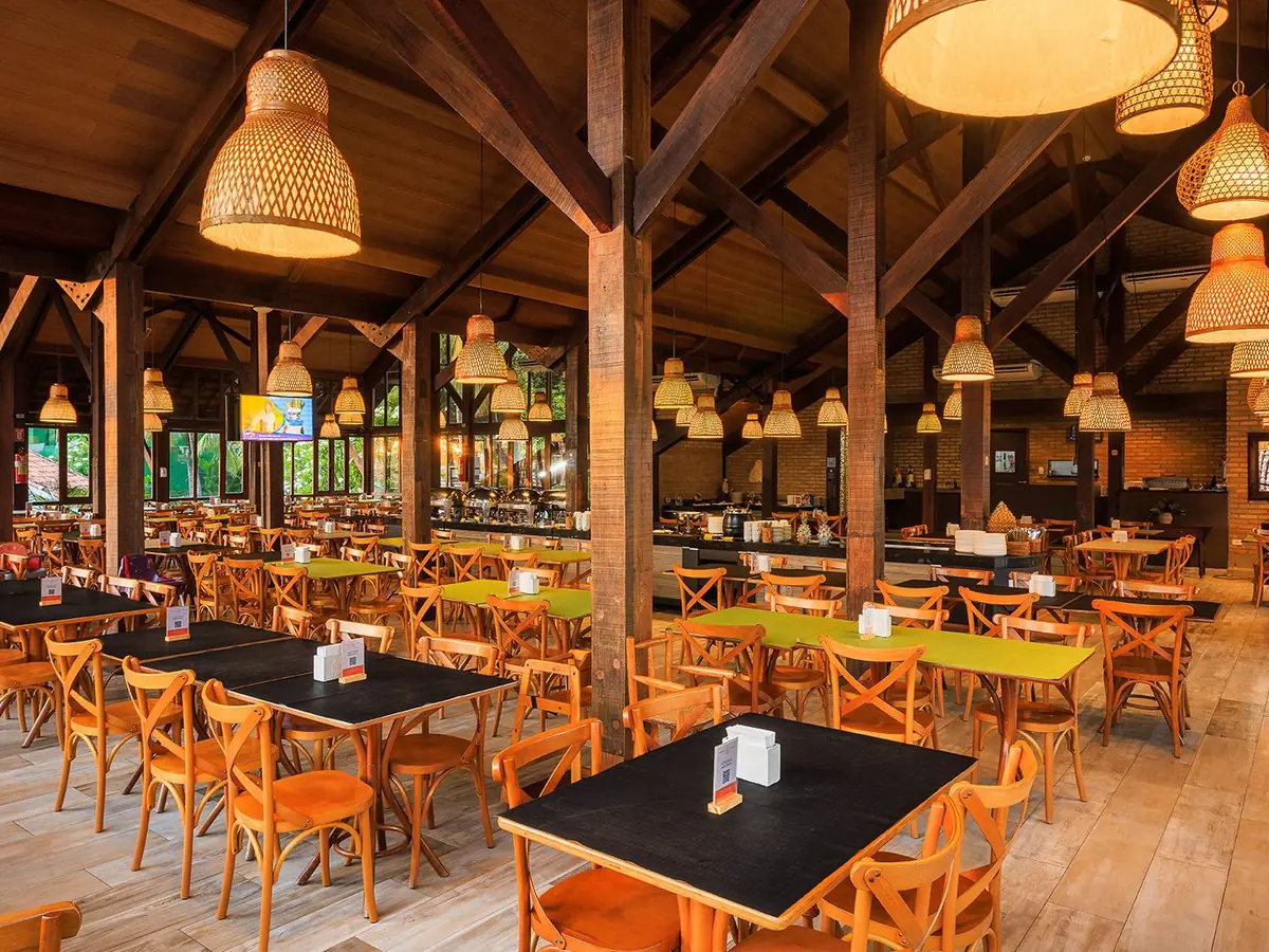 Salão do restaurante Cavalo-Marinho do Armação Resort, com luminárias de palha e janelas amplas