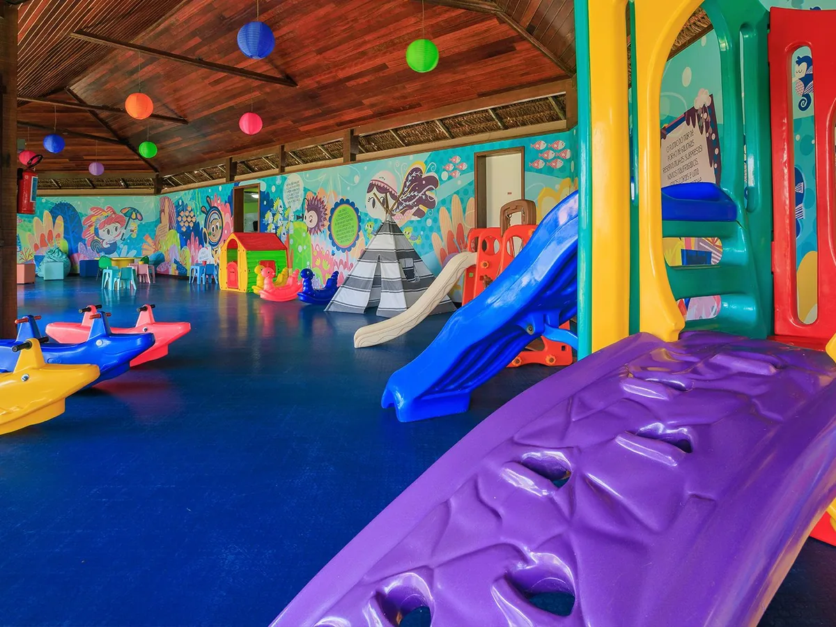 Brinquedoteca colorida do Kids Club do Armação Resort, com escorregadores e gangorras