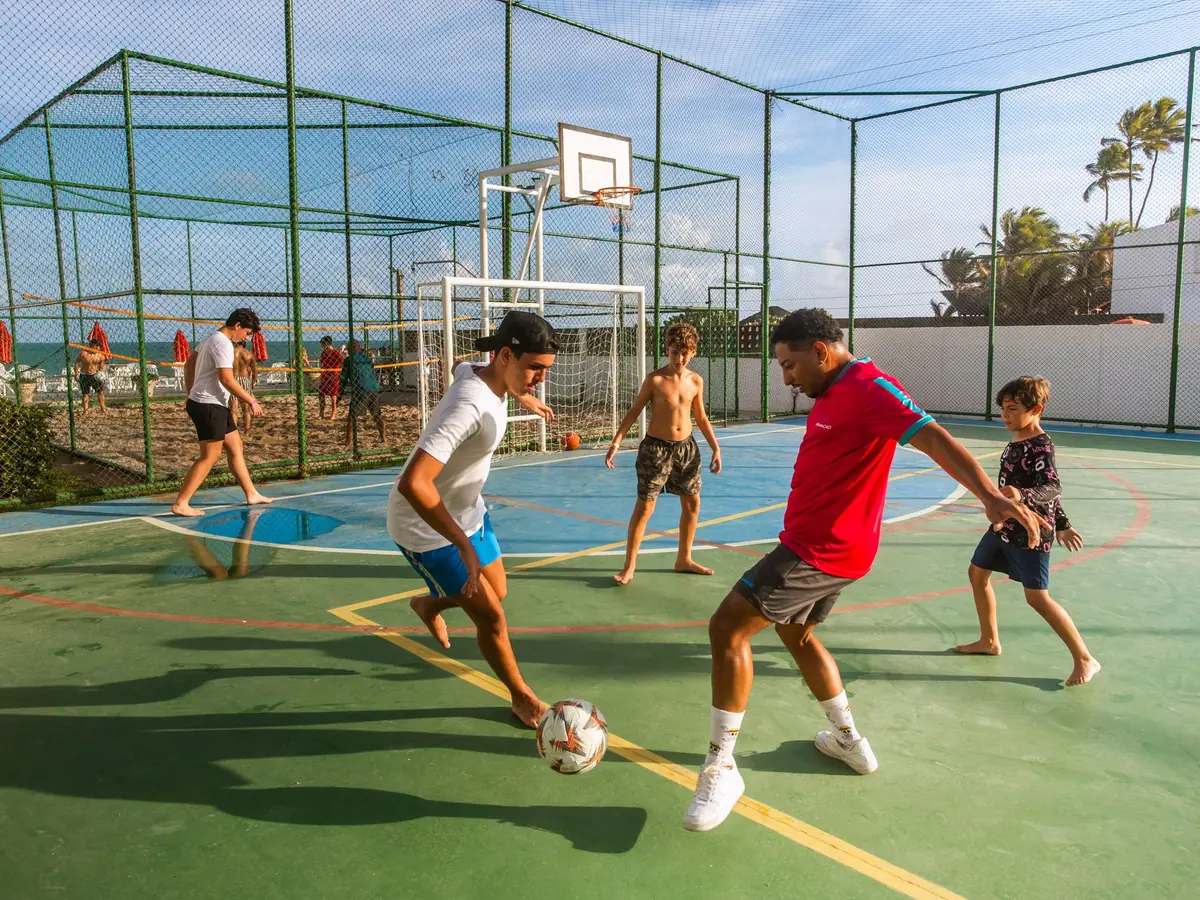 Futebol na quadra poliesportiva do Armação Resort, com a quadra de areia ao fundo