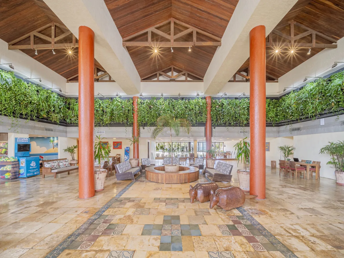 Recepção do Suites Beach Park, com pilares, teto de madeira e jardim vertical