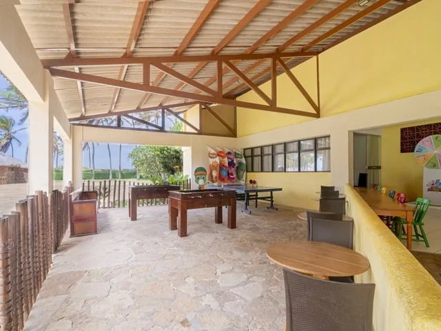 Sala de jogos coberta do Suites Beach Park, com pebolim e pingue-pongue, aberta para o jardim