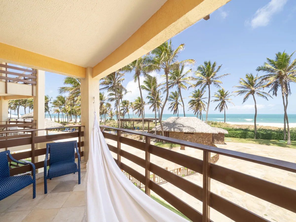 Varanda com rede no Suites Beach Park, de frente para o coqueiral e o mar