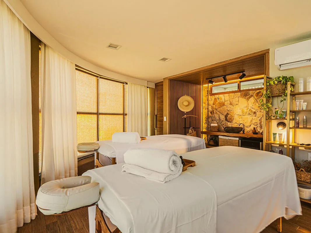 Sala do spa do Carmel Charme Resort, com duas macas de massagem lado a lado e cortinas claras