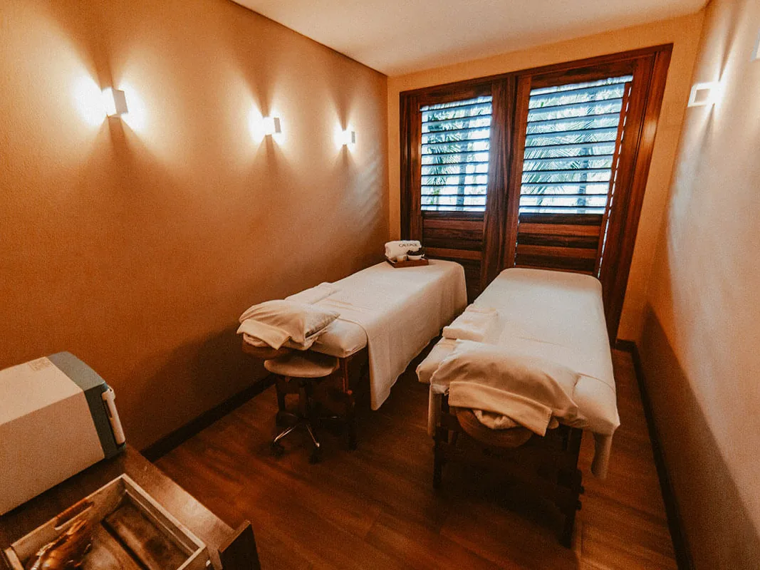 Sala de massagem do Spa Carmel by Caudalie, com duas macas e janelas de madeira