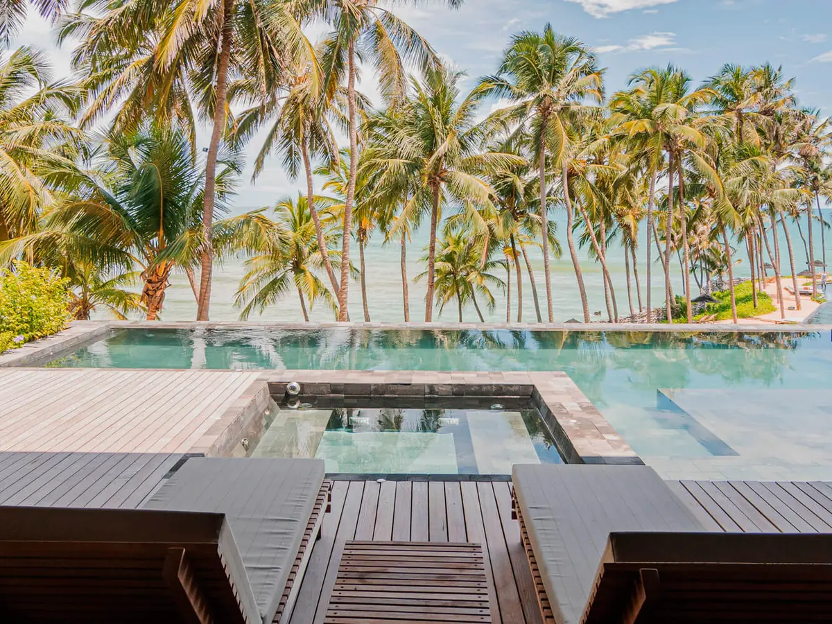 Deque da Vila Pássaro, com piscina privativa, hidromassagem e espreguiçadeiras de frente para o mar entre coqueiros