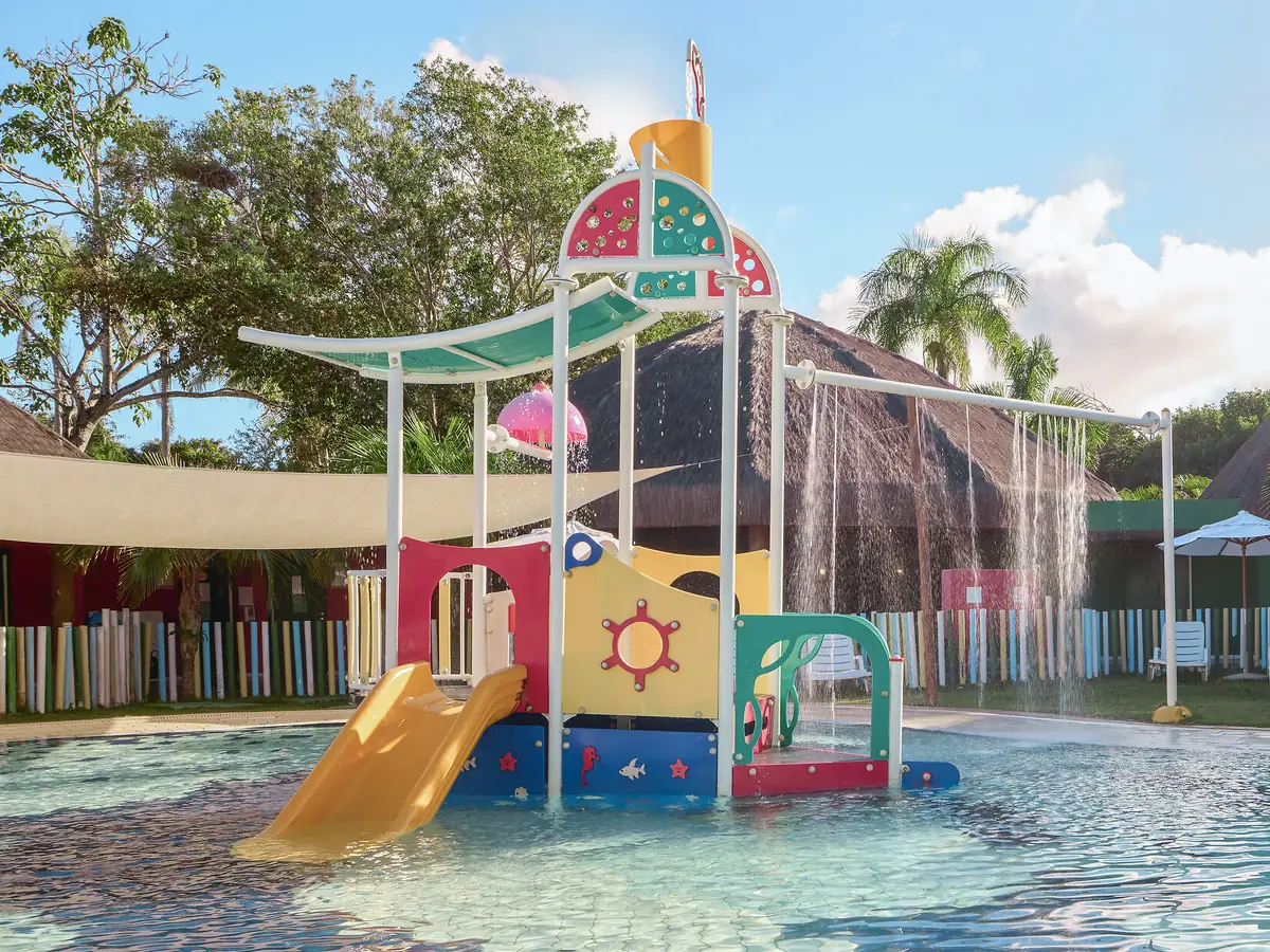 Piscina infantil rasa do Club Med Trancoso, com escorregador amarelo e brinquedo aquático colorido