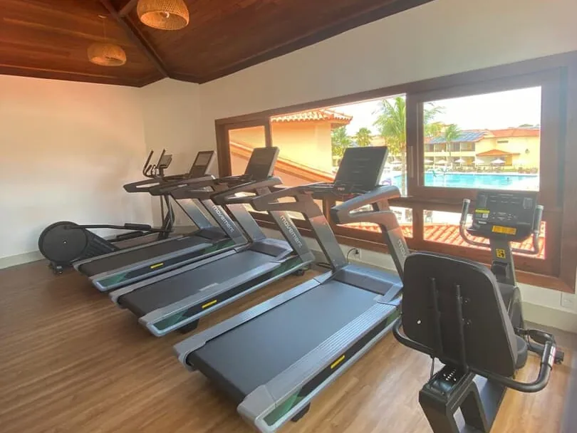 Esteiras da academia do Coroa Vermelha Beach, com janela para a piscina