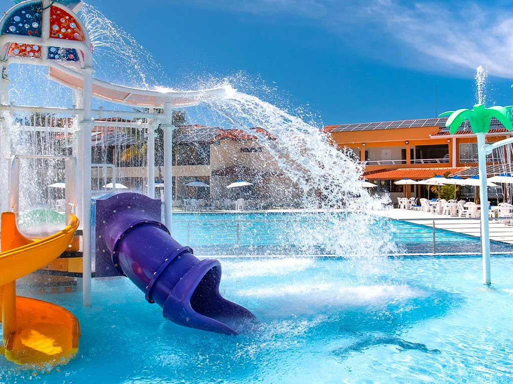Brinquedo aquático com escorregadores amarelo e roxo na piscina infantil do Coroa Vermelha Beach