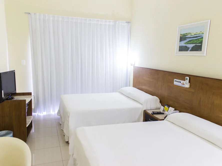 Quarto Standard do El Aram Imirá, com duas camas e cortina clara na janela