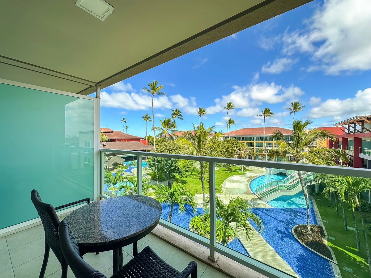 Varanda do apartamento Luxo Vista Piscina do Enotel Porto de Galinhas, com mesa e vista para as piscinas