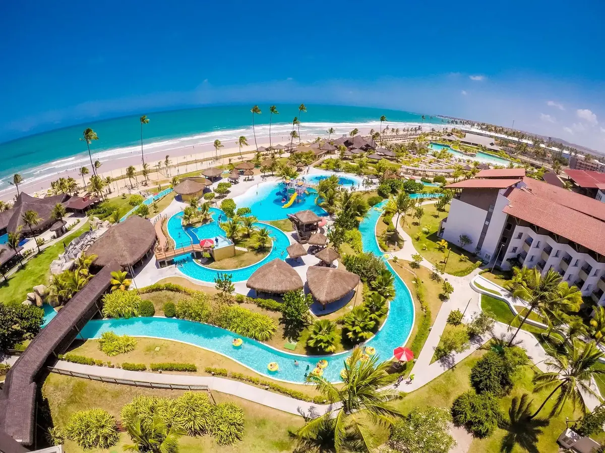 Rio lento e piscinas do Enotel Porto de Galinhas vistos do alto, com a praia ao fundo