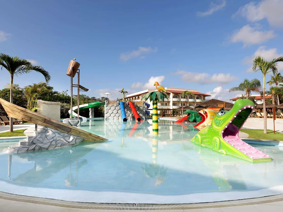 Splash Pool do Grand Palladium Imbassaí, com tobogãs coloridos e um jacaré de brinquedo dentro da água rasa