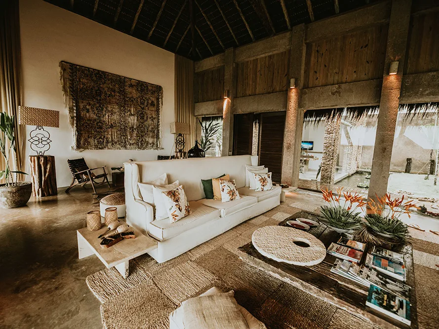 Sala de estar de uma villa do Kenoa Resort, com telhado de madeira e decoração eco chic