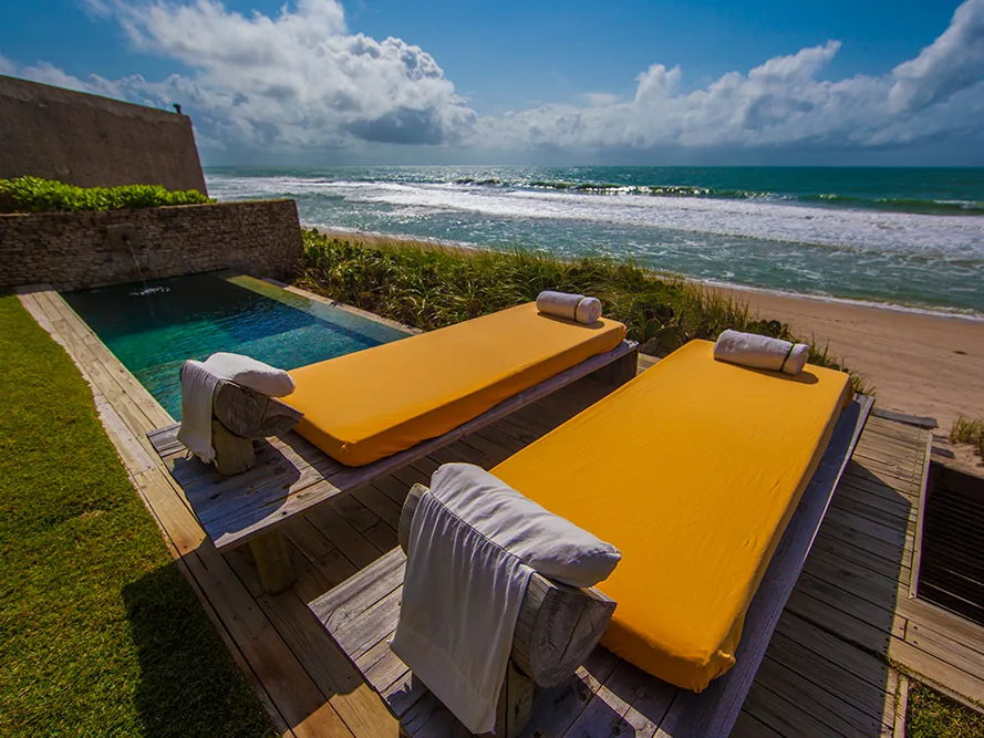 Piscina e espreguiçadeiras do Kenoa Resort, de frente para o mar de Barra de São Miguel