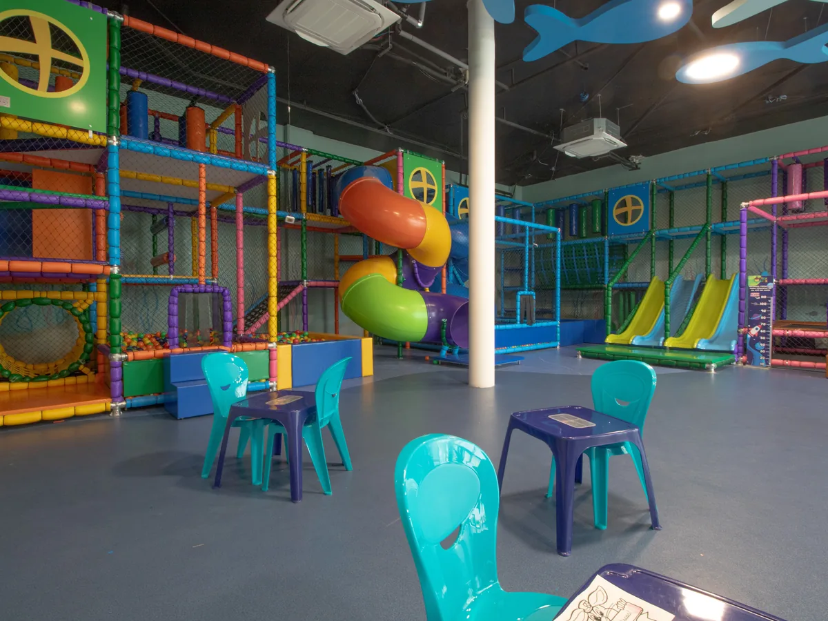 Brinquedoteca do Espaço Kids do Maceió Mar Resort, com estrutura de escalada, escorregadores e mesinhas