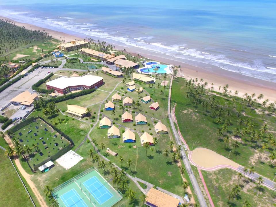 Vista aérea do Makai Resort, com os bangalôs, as quadras e a praia ao lado