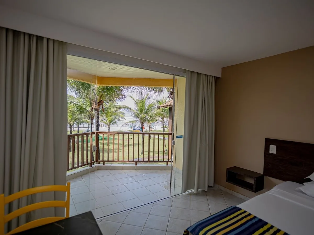 Apartamento Superior Vista Mar do Makai Resort, com a varanda aberta para os coqueiros