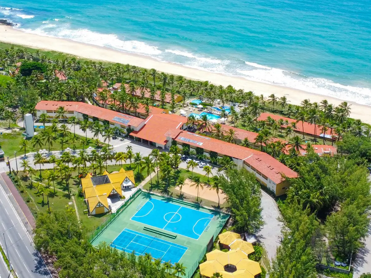 Vista aérea do Marsol Beach Resort, com a Via Costeira ao lado, as quadras, os telhados vermelhos, as piscinas e a praia