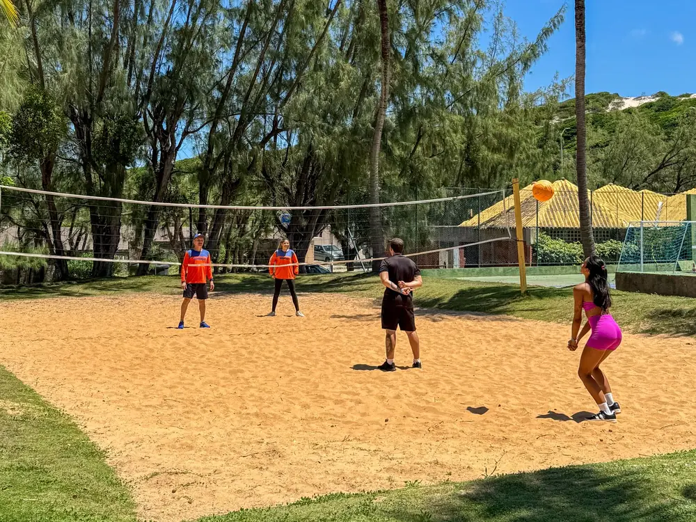 Hóspedes jogando vôlei de areia com a equipe de recreação do Marsol Beach Resort, entre as árvores