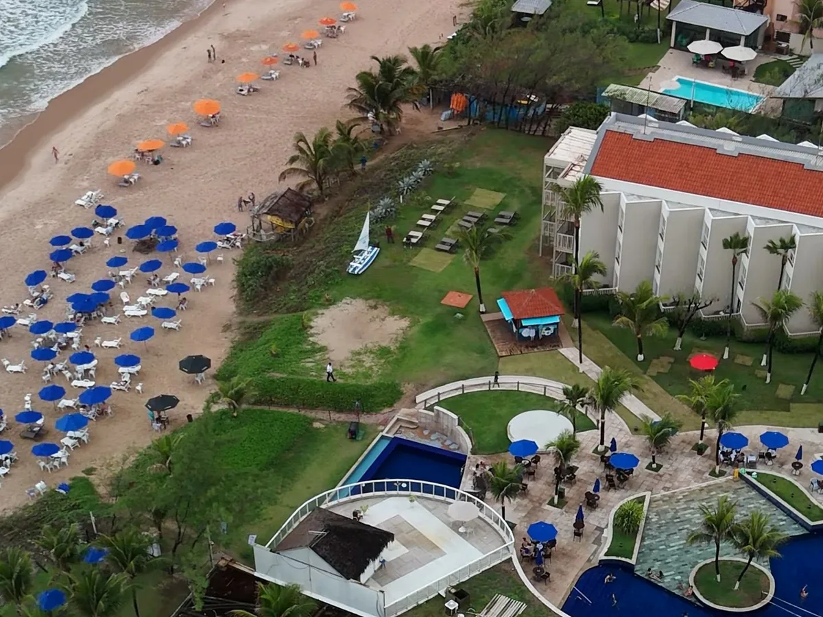 Vista aérea do Marupiara Resort, com as piscinas, o prédio e a praia em frente