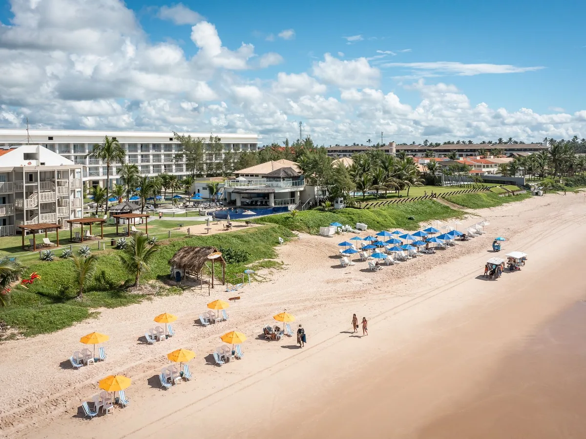 Praia de Porto de Galinhas em frente ao Marupiara Resort, com cadeiras e guarda-sóis na areia
