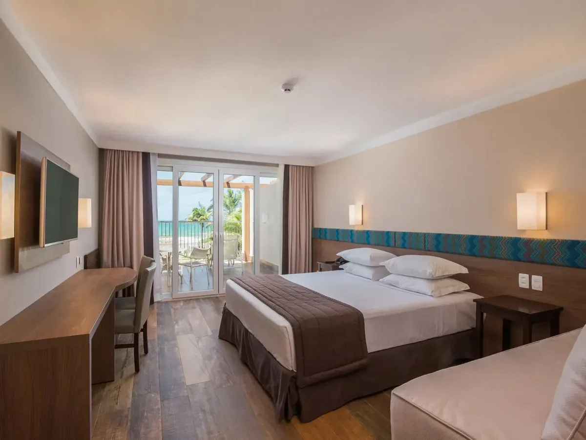 Apartamento do Marupiara Resort com cama de casal e porta para a varanda