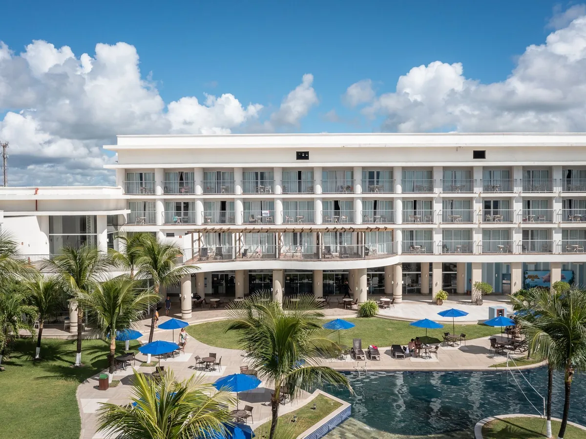 Prédio do Marupiara Resort com a piscina e os coqueiros, em Porto de Galinhas