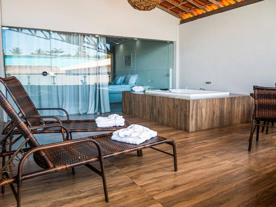 Varanda da Suíte Premium do Nauticomar Resort, com banheira, espreguiçadeiras e roupões dobrados