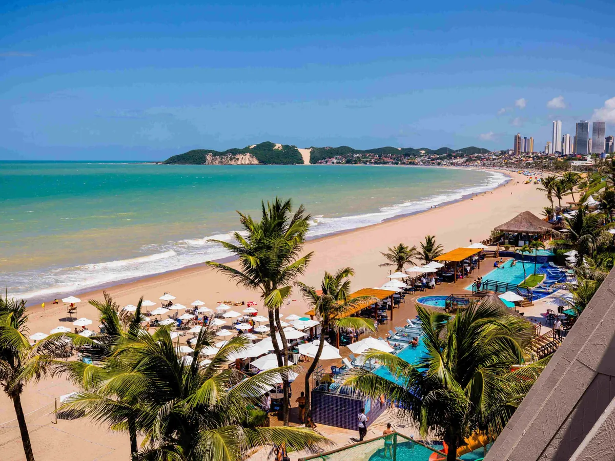 Praia de Ponta Negra vista do Ocean Palace, com guarda-sóis na areia e o Morro do Careca ao fundo
