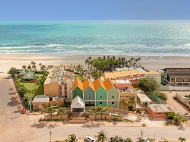 Vista aérea do Oceani Beach Park, com os prédios coloridos, a praia e o mar