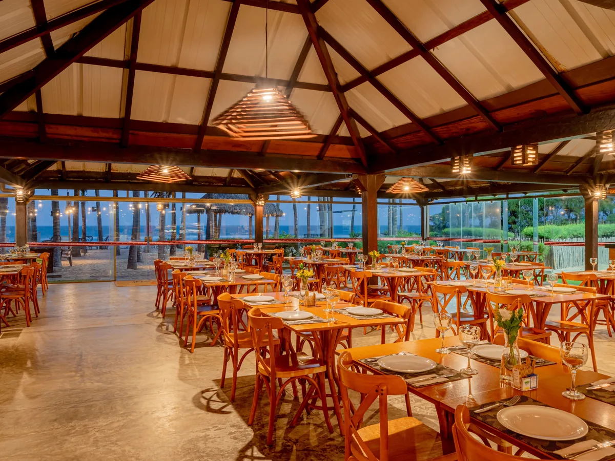 Restaurante do Oceani Beach Park, com mesas de madeira e vista para o mar