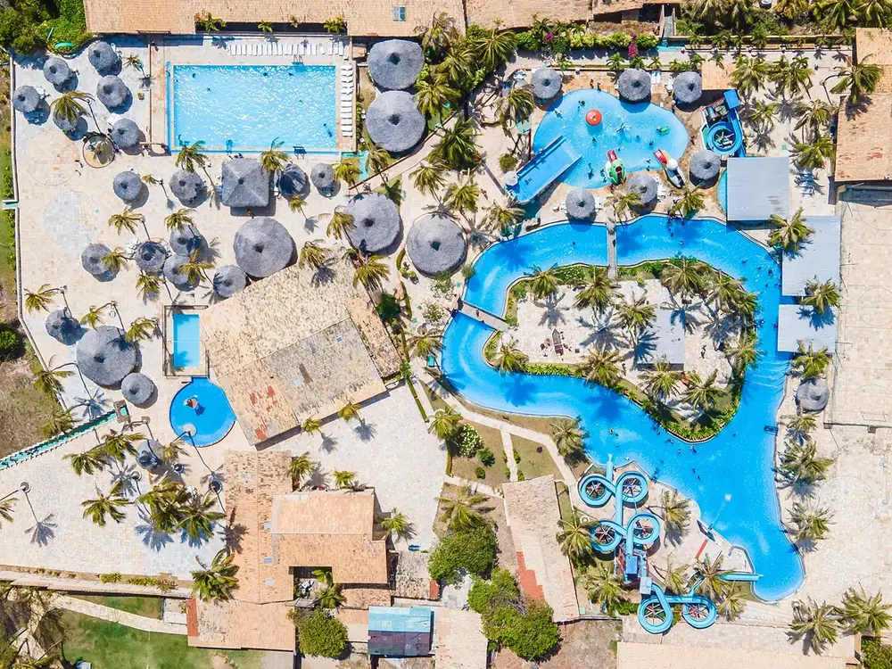 Vista aérea do Hotel Parque das Fontes, com a piscina que contorna uma ilha, os toboáguas e os quiosques de palha