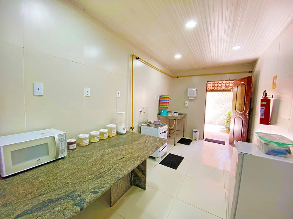 Cozinha do bebê do Hotel Parque das Fontes, com bancada de granito, micro-ondas, fogão e potes de mantimentos