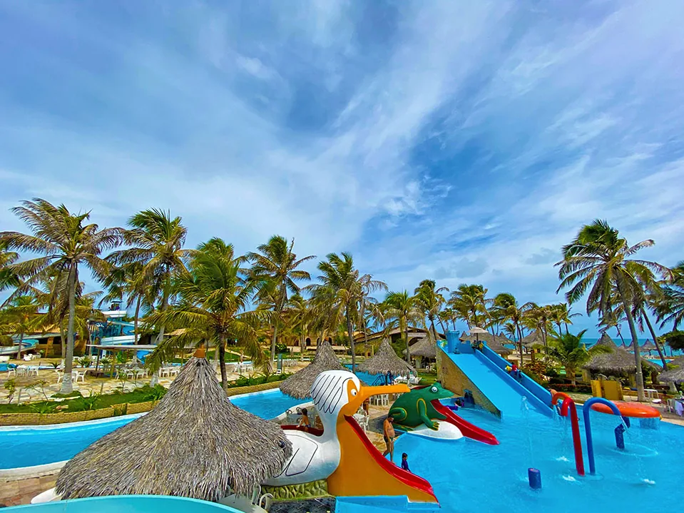 Área infantil do parque aquático do Hotel Parque das Fontes, com escorregadores de pelicano e de sapo e um toboágua azul