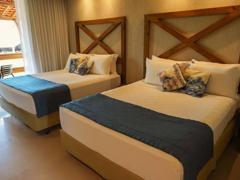 Suíte Família Superior do Pratagy Beach Resort, com duas camas de casal e a porta aberta para a varanda