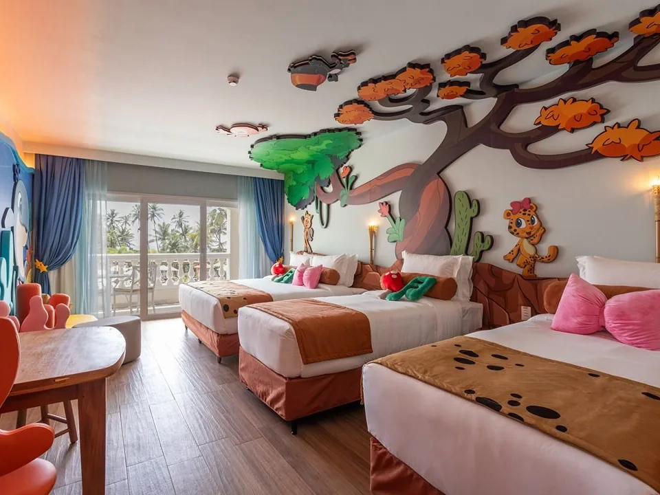 Quarto temático da Turminha da Zooeira no Sauípe Sol Grand Premium, com árvore e personagens na parede e três camas