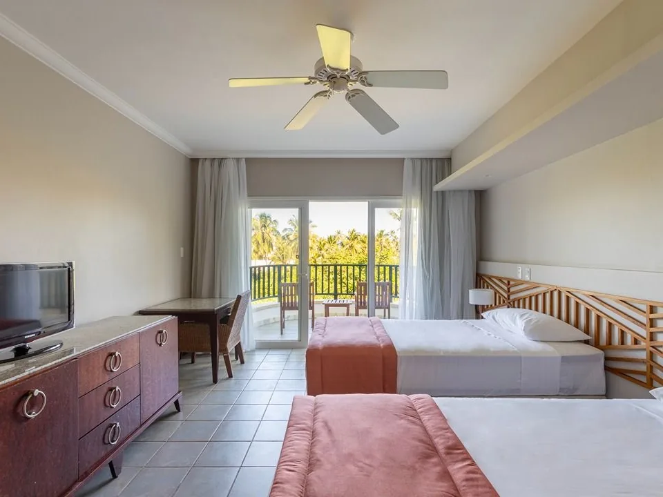Apartamento Superior do Sauípe Terra Resort com duas camas, ventilador de teto e porta aberta para a varanda