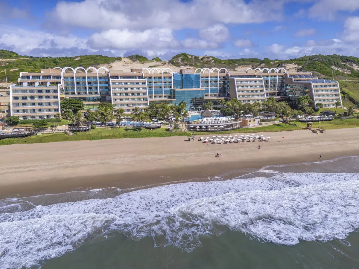 O SERHS Natal visto do mar, com a praia em frente e as dunas atrás