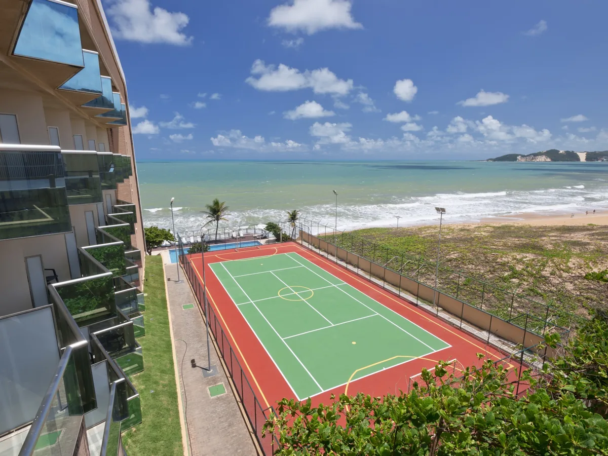 Quadra poliesportiva do SERHS Natal ao lado da praia, vista de uma varanda, com o mar ao fundo