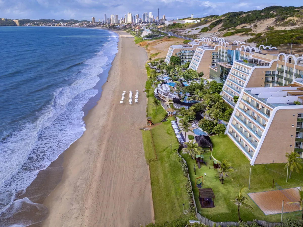O SERHS Natal visto do alto, com os prédios escalonados à beira da praia e a orla de Ponta Negra ao fundo