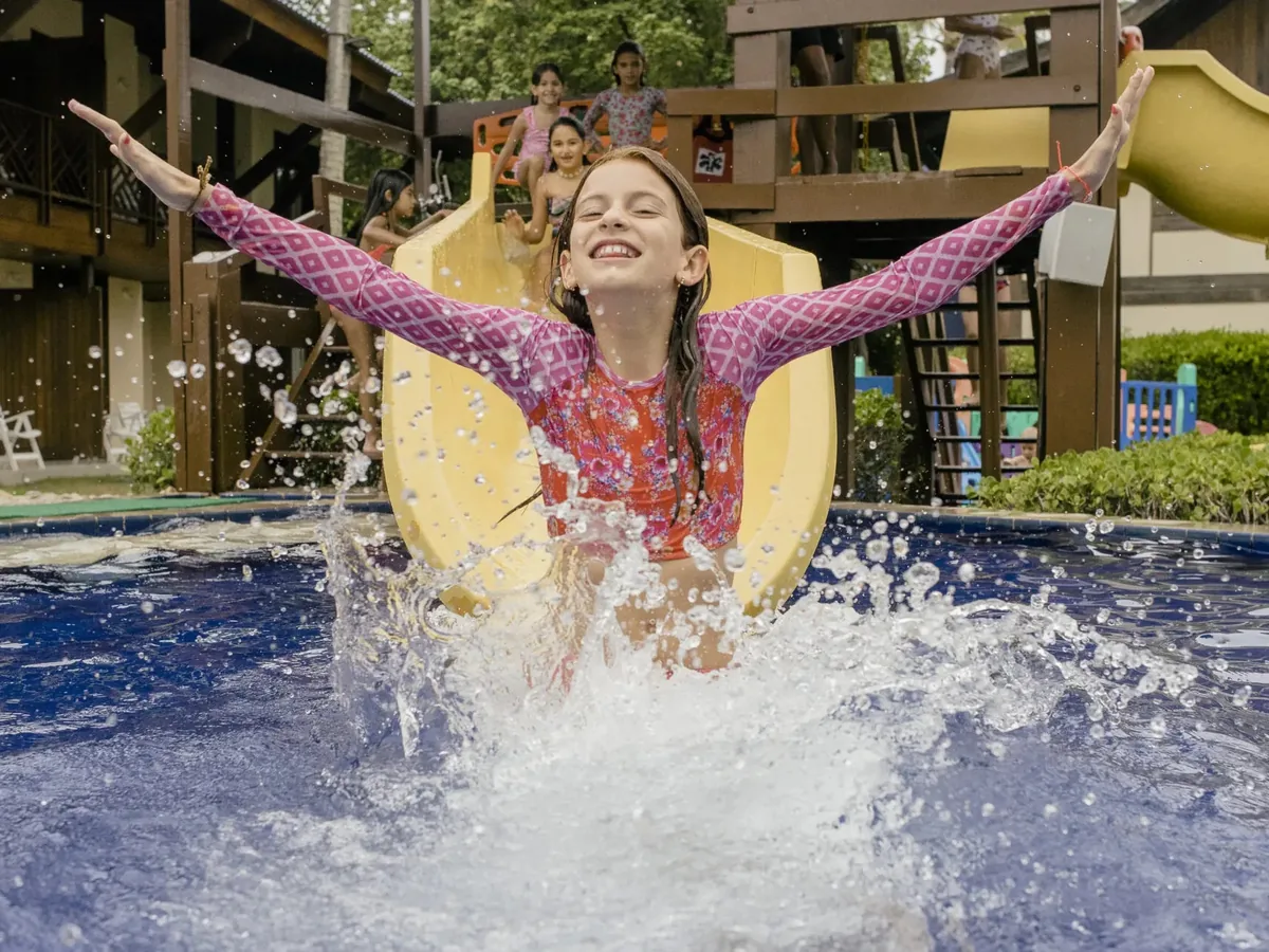 Menina descendo o toboágua da área infantil da piscina do Summerville