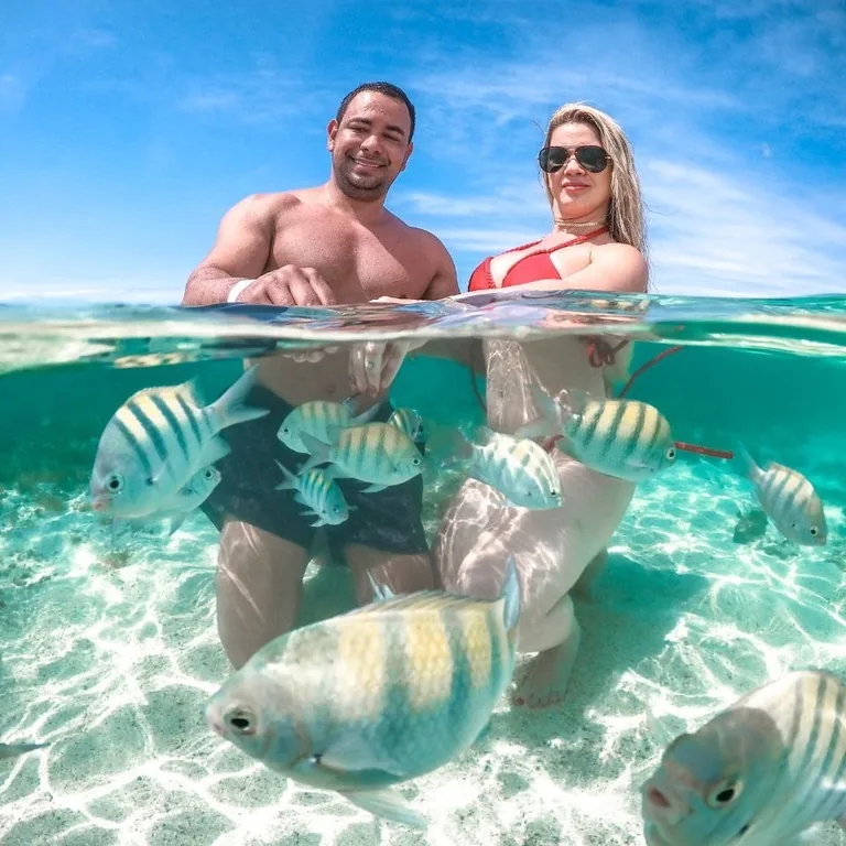 Rafael e Silu, da BSS Turismo, nas piscinas naturais de Maragogi, cercados de peixes