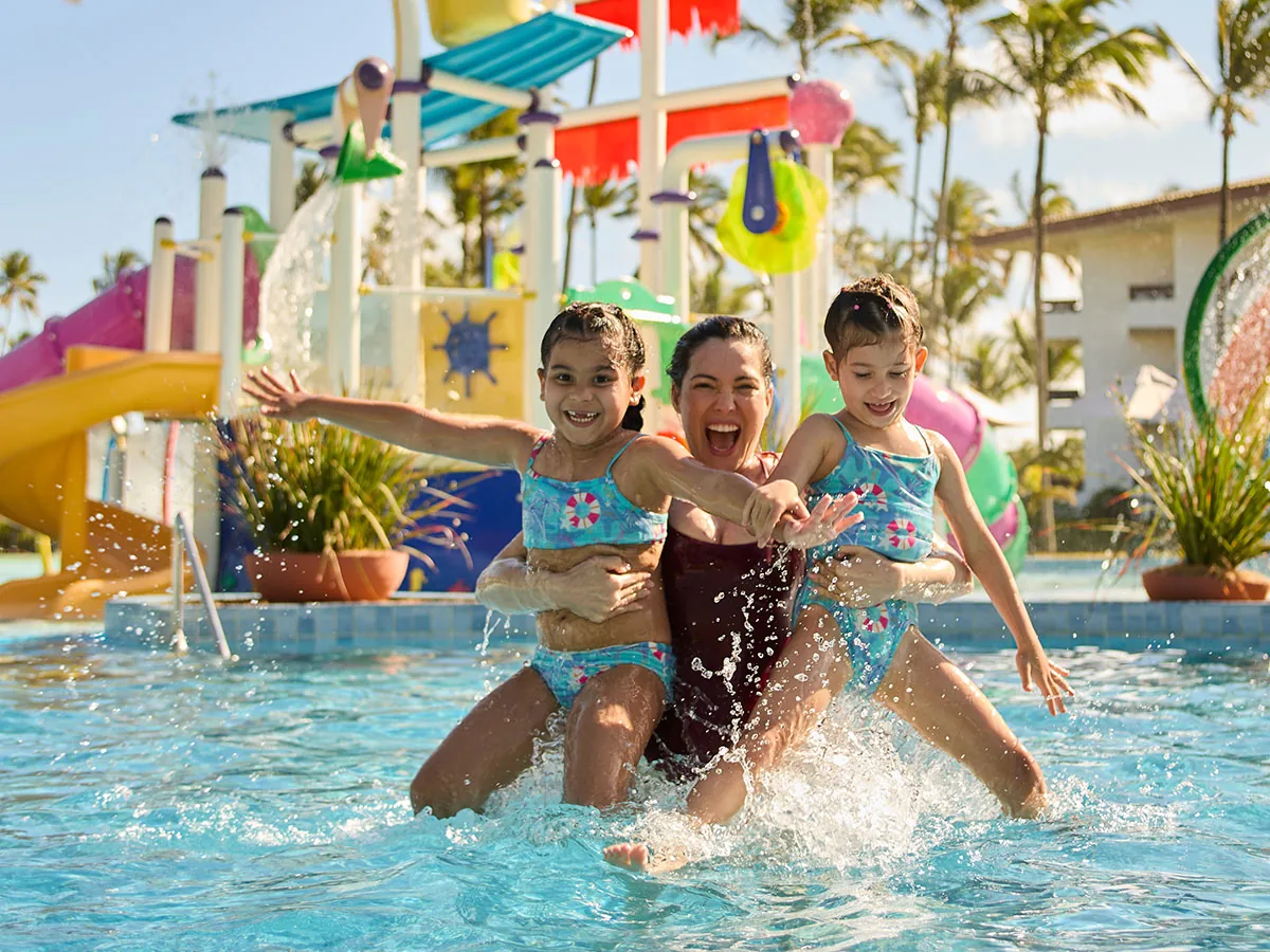 Mãe e duas filhas brincando na piscina do Tobby, no Transamerica Comandatuba, com escorregadores ao fundo