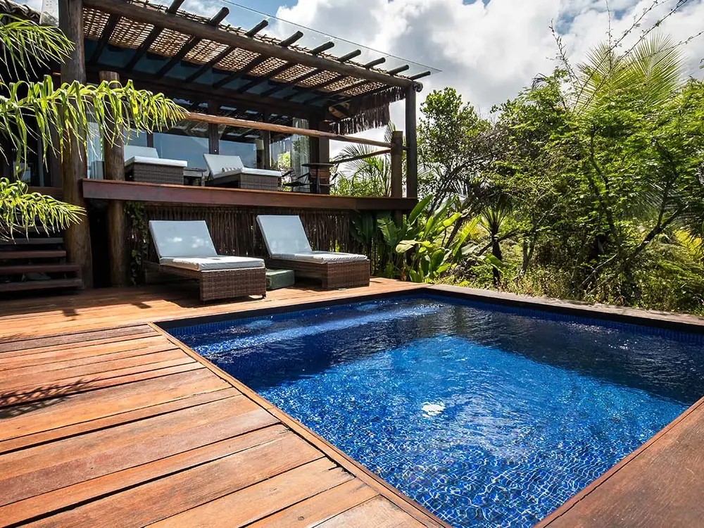 Bangalô Premium do Txai com piscina privativa no deck de madeira, espreguiçadeiras e mata em volta