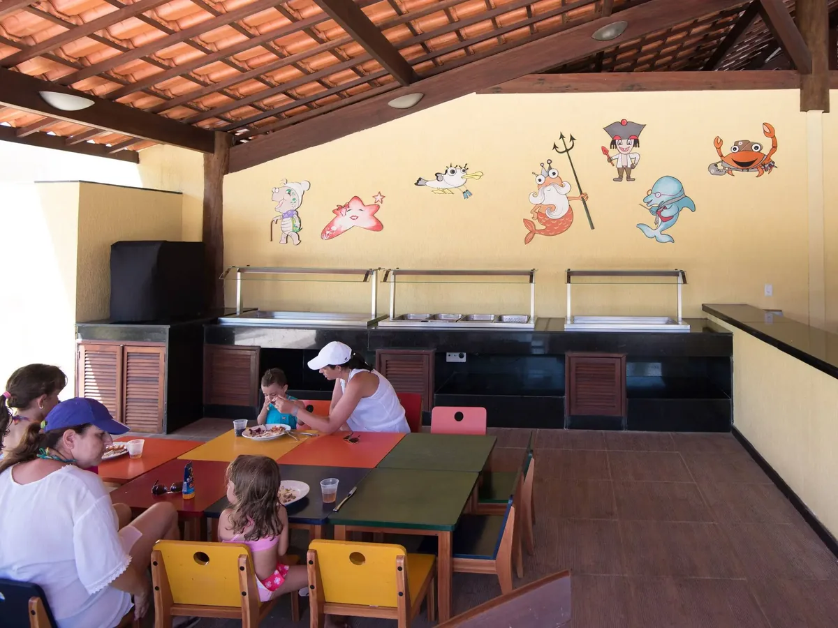 Espaço infantil do restaurante do Vila Galé Cabo, com mesas baixas e decoração de fundo do mar