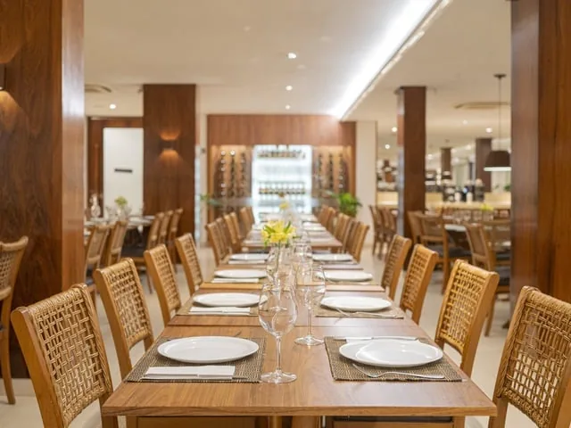Salão do restaurante do Wellness Beach Park, com mesas postas e cadeiras de fibra