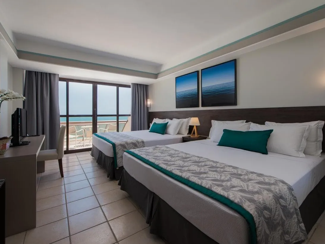 Quarto do Wish Natal Resort com duas camas e janelas de frente para o mar