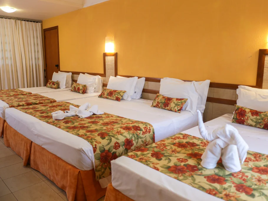 Quarto do Aguativa com camas arrumadas e colchas floridas